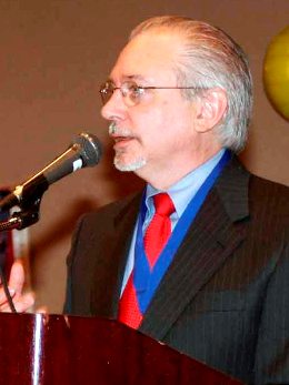 Theo responds to member questions at the lectern.